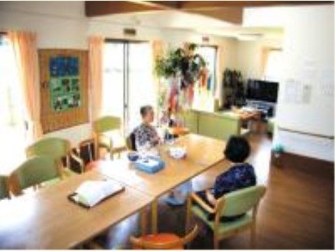 食卓とソファ、テレビが置かれ、窓が多く明るい1階のリビング