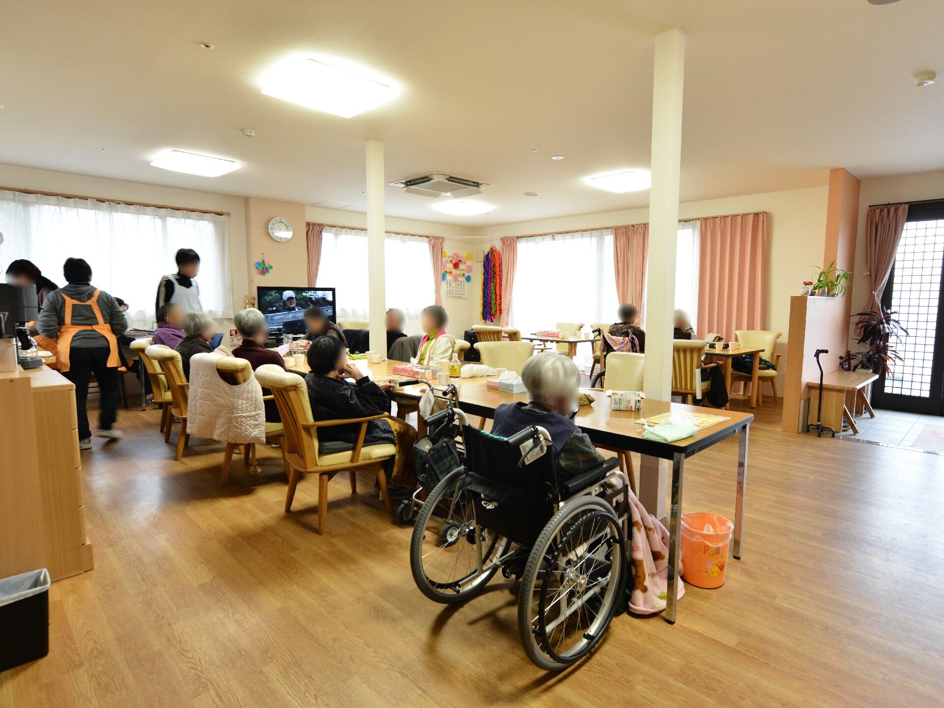 テーブルセットの周りに集まって、スタッフの説明を聞いている入居者様
