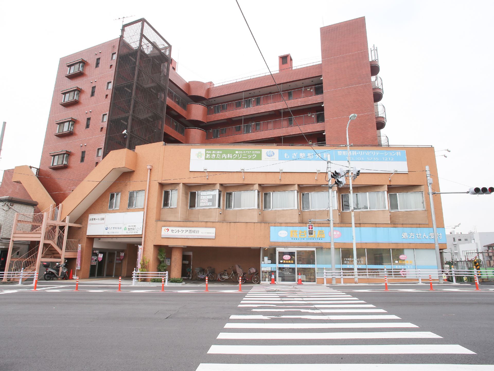 大きな交差点の奥にある、１階に薬局が入居している建物