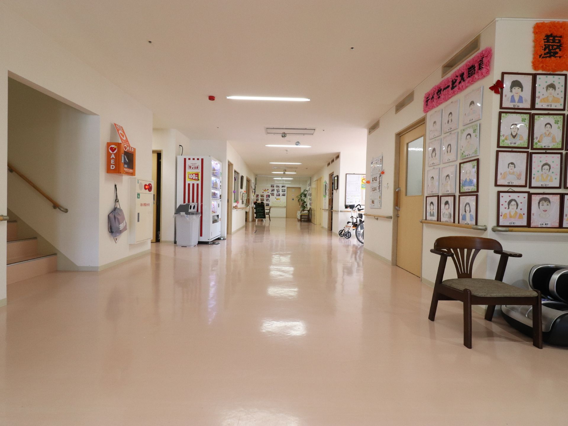 廊下の一角には、AEDが設置してある。壁には、似顔絵が掲示されており、椅子、自動販売機などが用意されている。