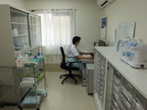 窓の前に置かれたデスクで事務処理をしているスタッフ