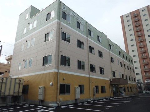 ナチュラルテイストを基調とした、地上４階の鉄筋コンクリート建てである。施設の周囲には駐車スペースも確保されている。