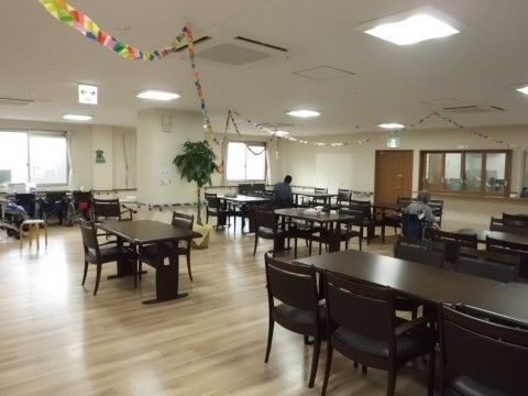 光を多く取り入れた室内には、椅子やテーブルが設置されている。天井には折り紙で作られた飾りが手作りの温かみを感じさせる。
