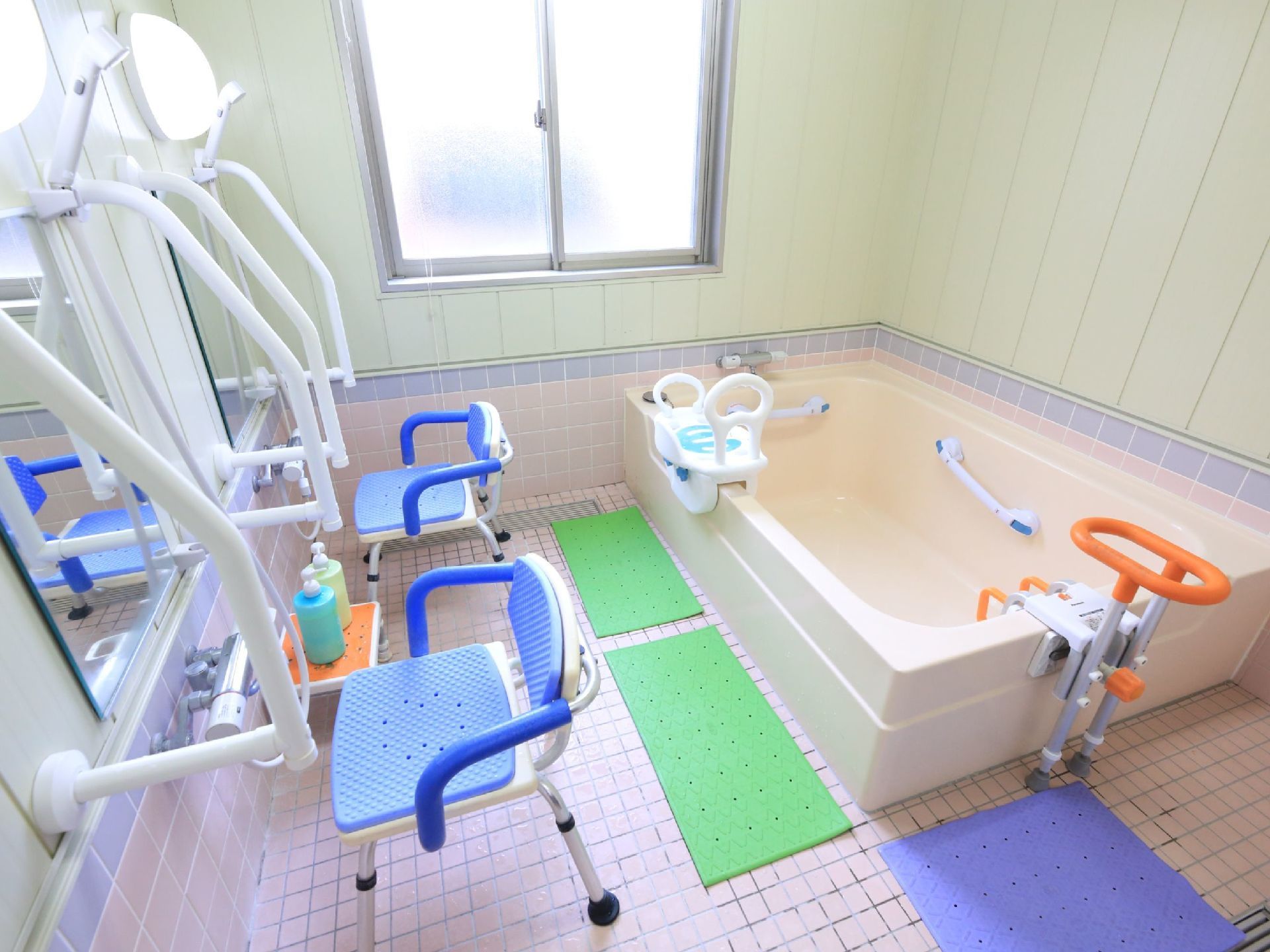 介護浴室には、滑り止めマットや浴槽手すり、シャワーチェアが用意されている。２箇所の洗い場が設けられている。
