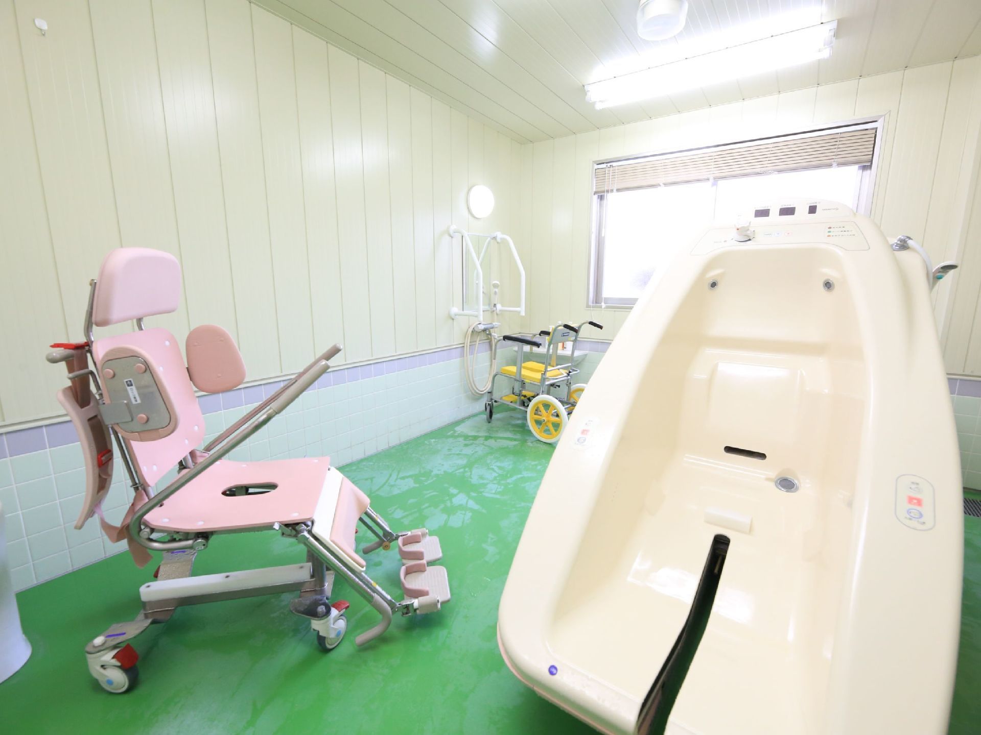 広々とした機械浴室である。専用キャリーが備わった介護浴槽が完備されている。左奥に手すり付きの洗い場が設けられている。