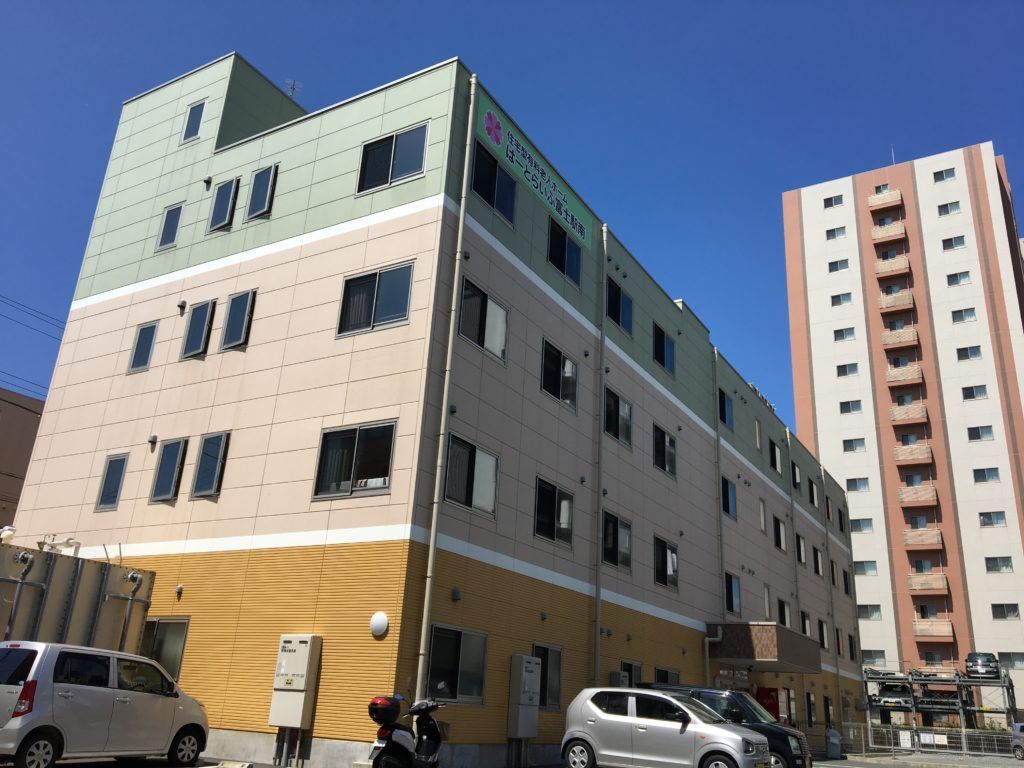 施設は３色に塗られた外壁が特徴的な４階建ての建物である。左側に外階段が設置されている。建物右の居室階には、ベランダが設けられている。