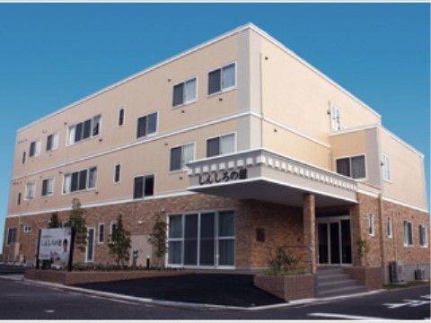 １階が茶色のレンガ造り、２階から上がベージュに塗られた建物