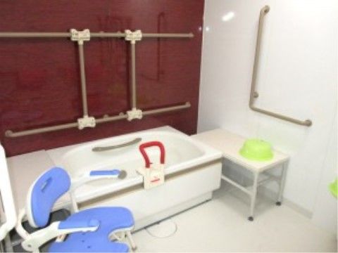 浴室の壁に、立ち上がりが安全に行えるよう手すりを設置している。シャワーチェアは座高が高いため、足腰の負担が少ない。