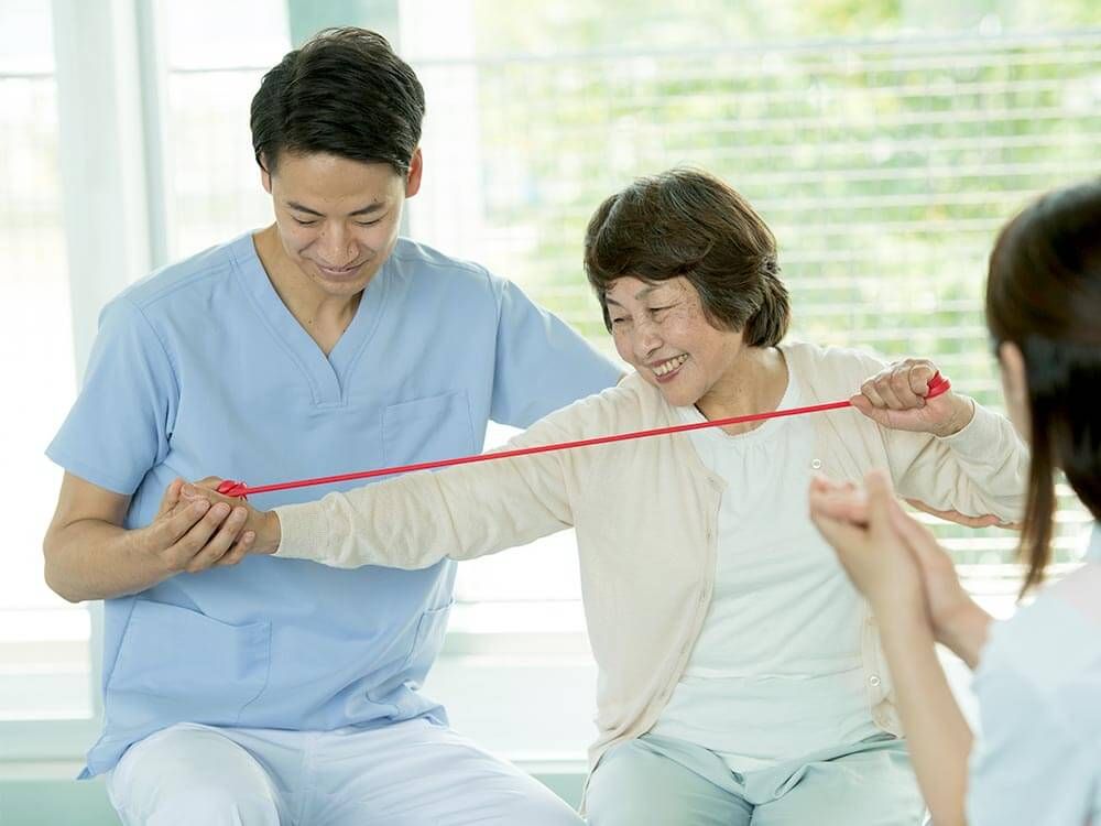 白い椅子に腰かけてスタッフの診察を受けている入居者様