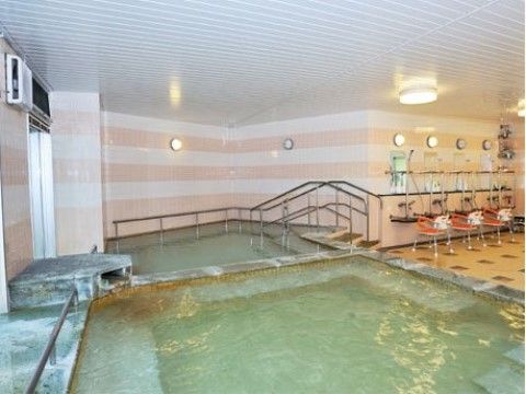 ステンレス製の手すりが設置された大きな浴槽があるお風呂