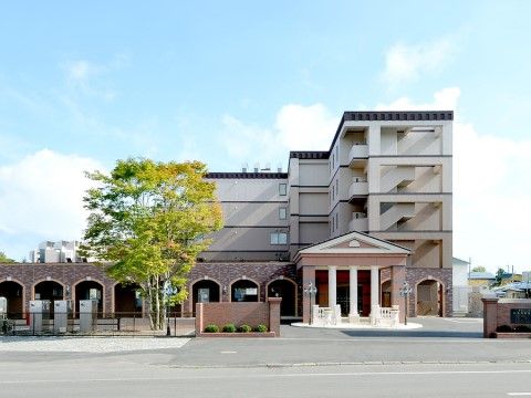 建物の４階部分まで届く大きな樹木が生えている施設外観