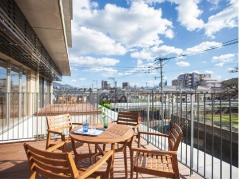 丸テーブルを囲むように椅子が置かれた、共用部から出られるテラス