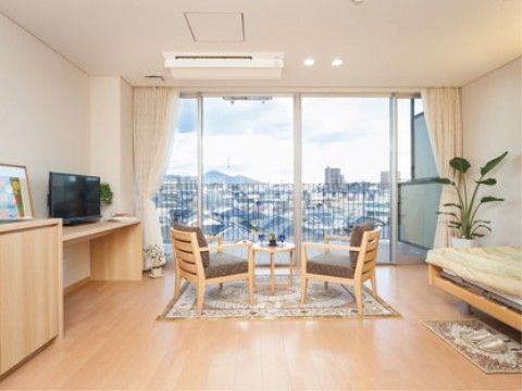 大きな窓の向こうに街の景色が遠くまで見えている居室
