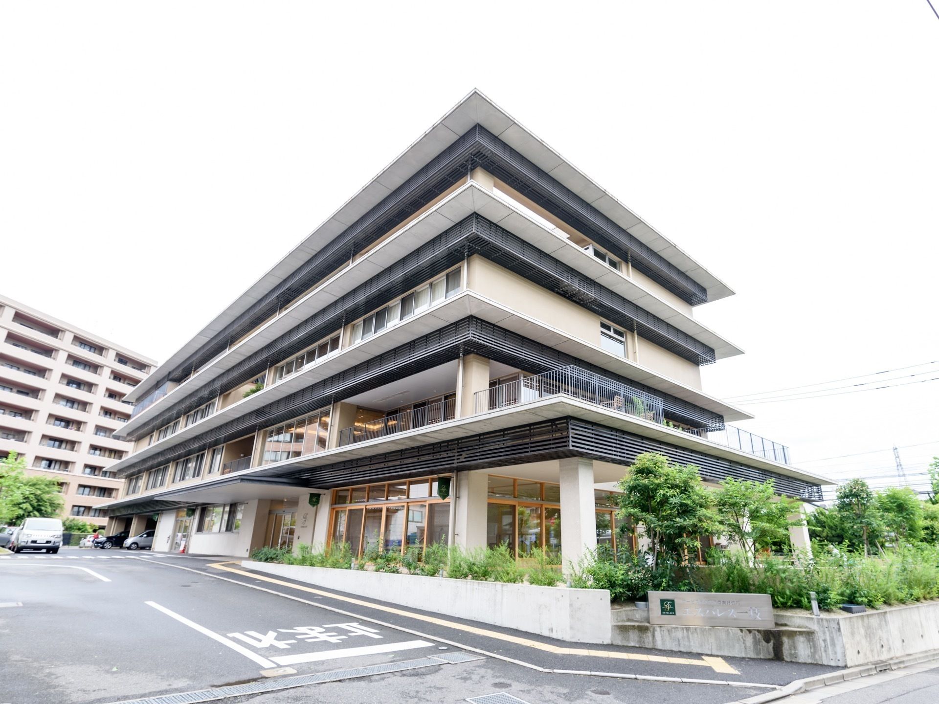 建物は4階建てで、濃淡の茶系色を基調色としている。２～４階は窓が多く、十分な採光が期待できる設計である。