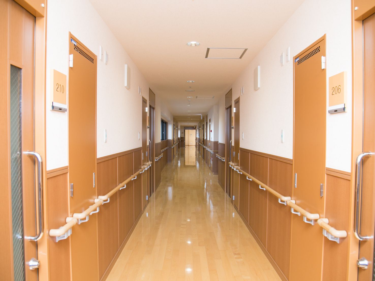 各居室のエントランスには部屋番号を表示。壁面全てに手すりが完備され安全に移動ができる。床はピカピカに磨かれている。