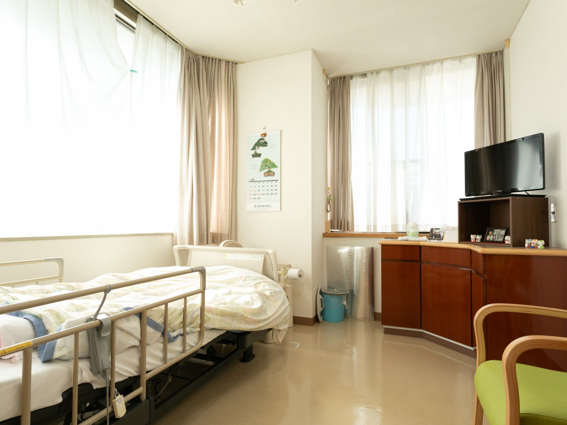 車椅子で外出をする高齢女性と介助をする女性ヘルパー