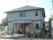 建物の入り口までは緩やかなスロープになっており、入り口の上は張り出した屋根が付けられている。フェンスには花が掛けられている。