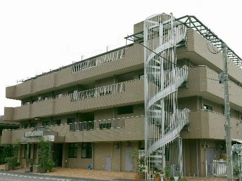 らせん型の非常階段がとても目立つな３階建ての老人介護施設