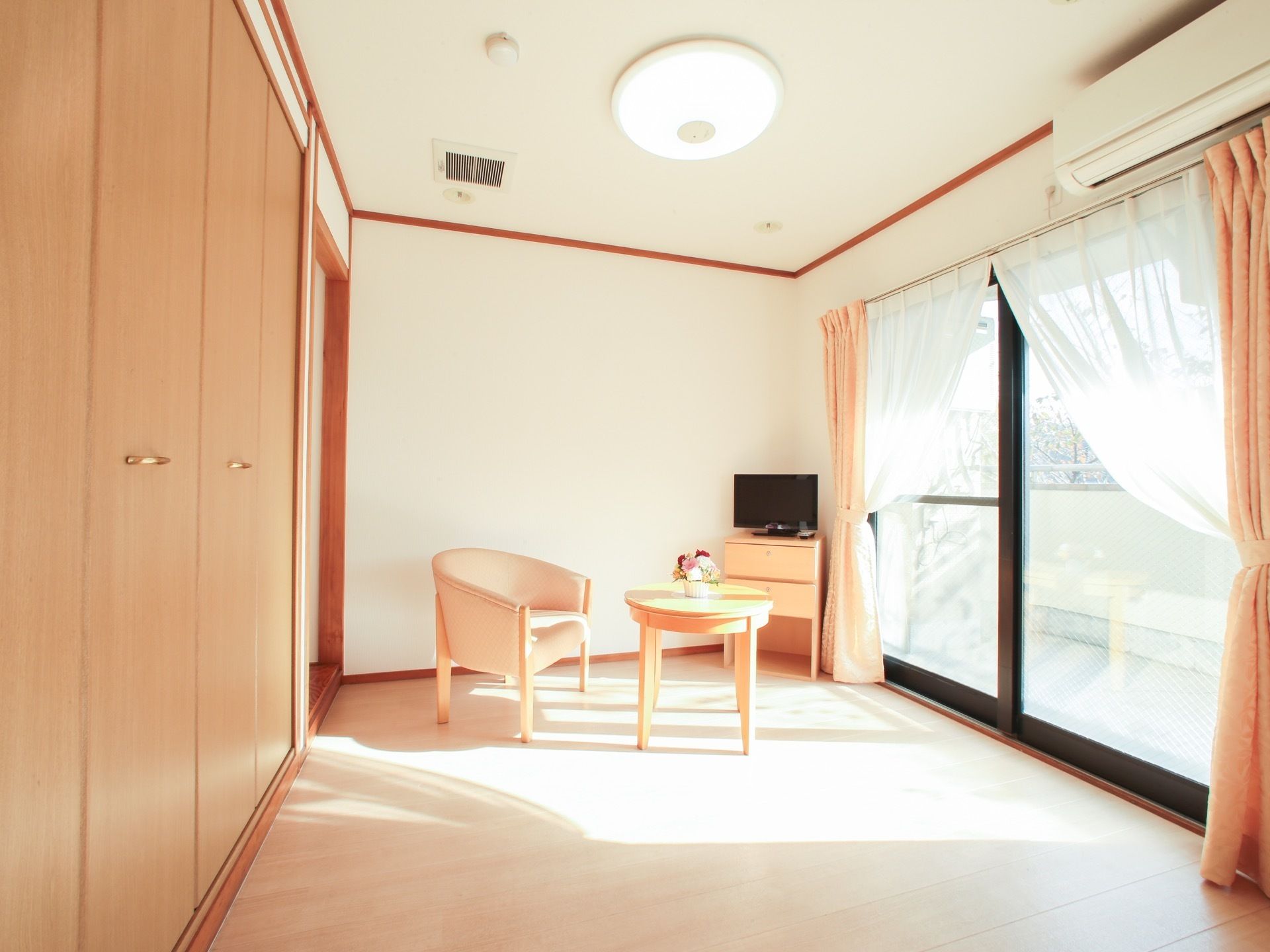 日当たりがよく日射しの差し込む居室には、液晶テレビやソファ、テーブルを完備している。窓から見える景色が美しい。