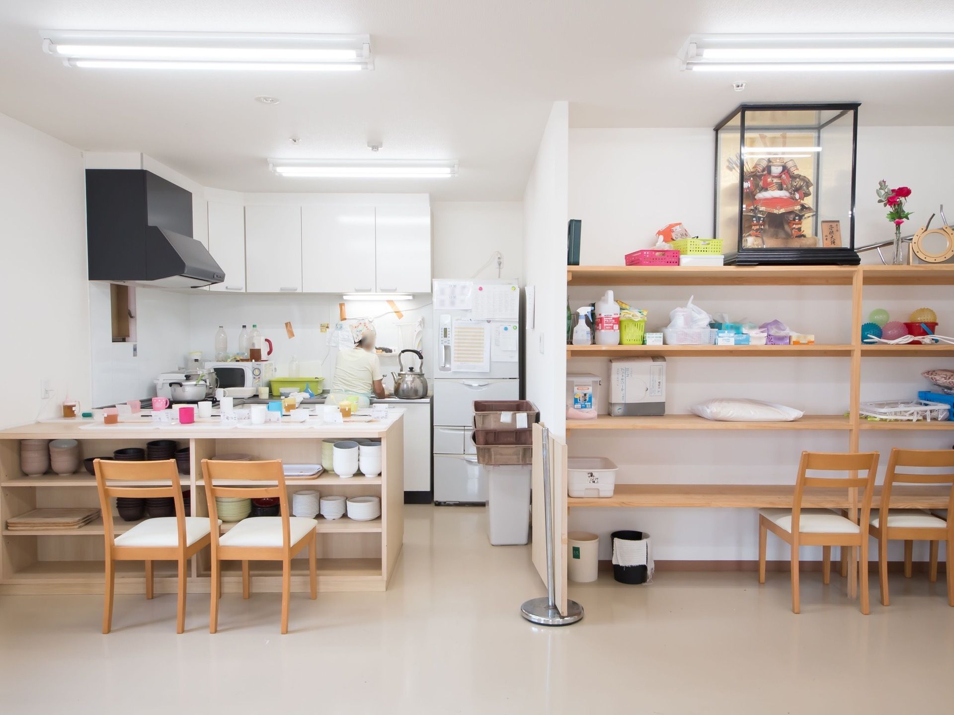 低いカウンターのあるオープンキッチンで、スタッフが作業をしている。カウンターには配膳の準備がされているところである。