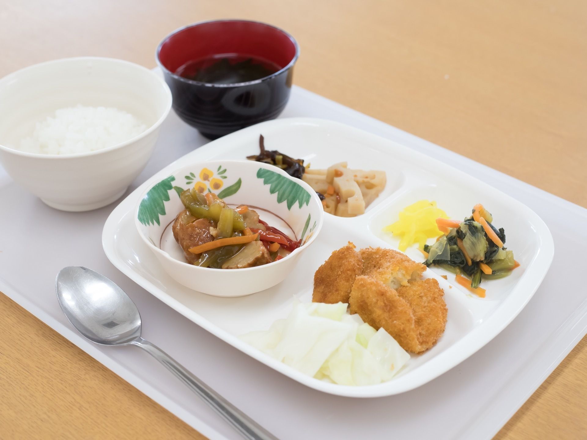 白いお盆の上に、ご飯と汁物、おかずの載ったお皿が置かれている。おかずはさまざまな食材を使い、幾つもの味が楽しめるようになっている。