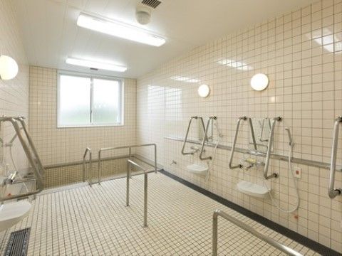 壁面、床はホワイトのタイル張りである。下り階段式の浴槽があり、２，３人が入れるほどの大きさである。壁面と通路に手すりが付いている。