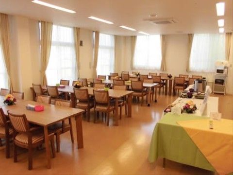 広いスペースに、木製のテーブルセットが複数設置されている。窓が２面に取られ、明るい。床面ははフローリングで段差がない。
