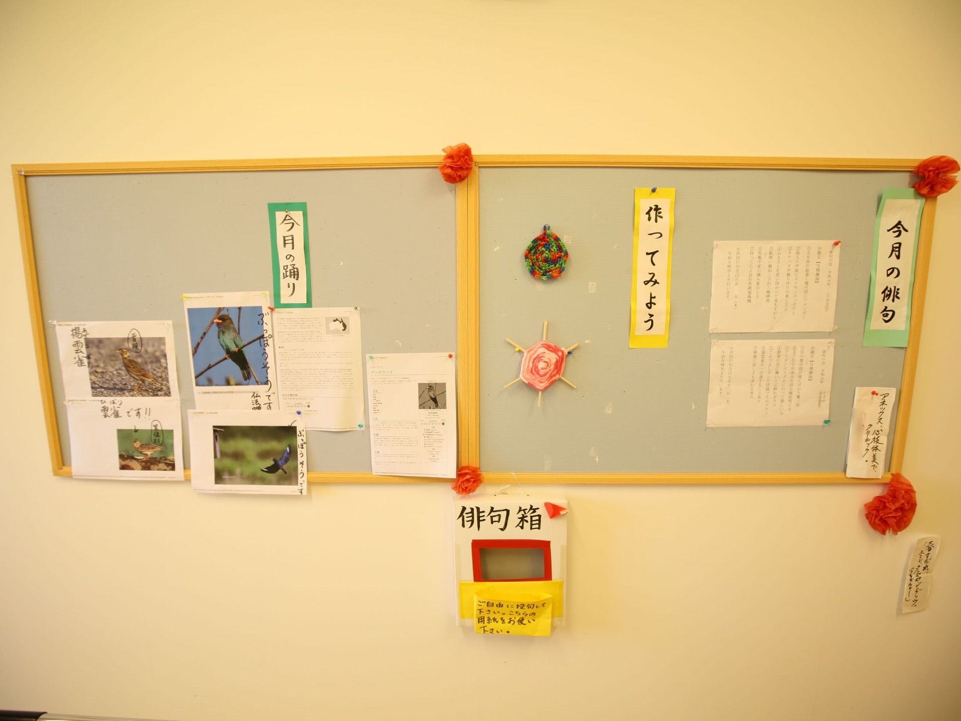ボードに、今月の俳句や毛糸で作られた作品、写真などが飾られている。ボードの下に自由に俳句を詠み、提出できる箱が設置されている。