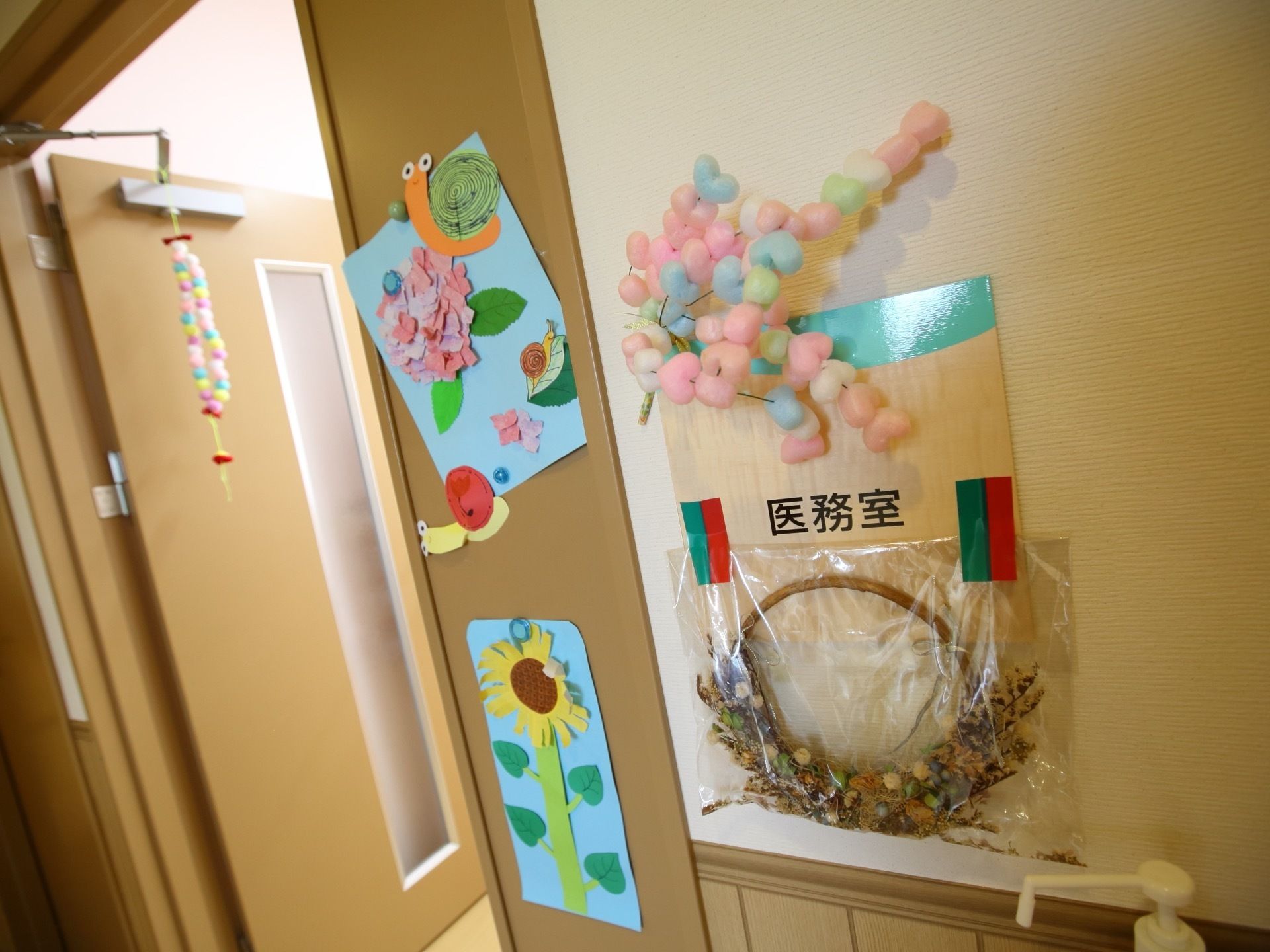 医務室の看板の周りにドライフラワーの作品が飾られている。ドアの周りには季節ならではの作品が展示されている。