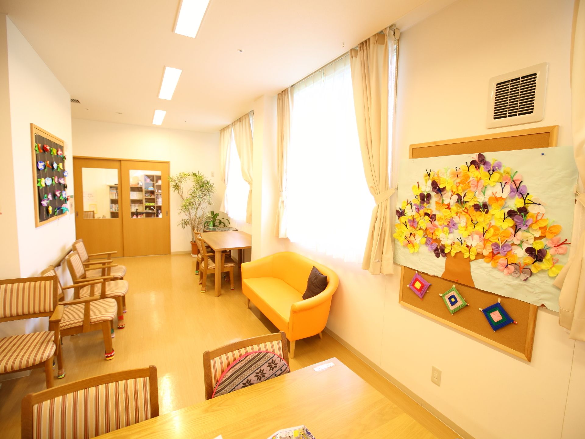 壁のコルクボードに入居者様が作成した作品などが飾られて共有部