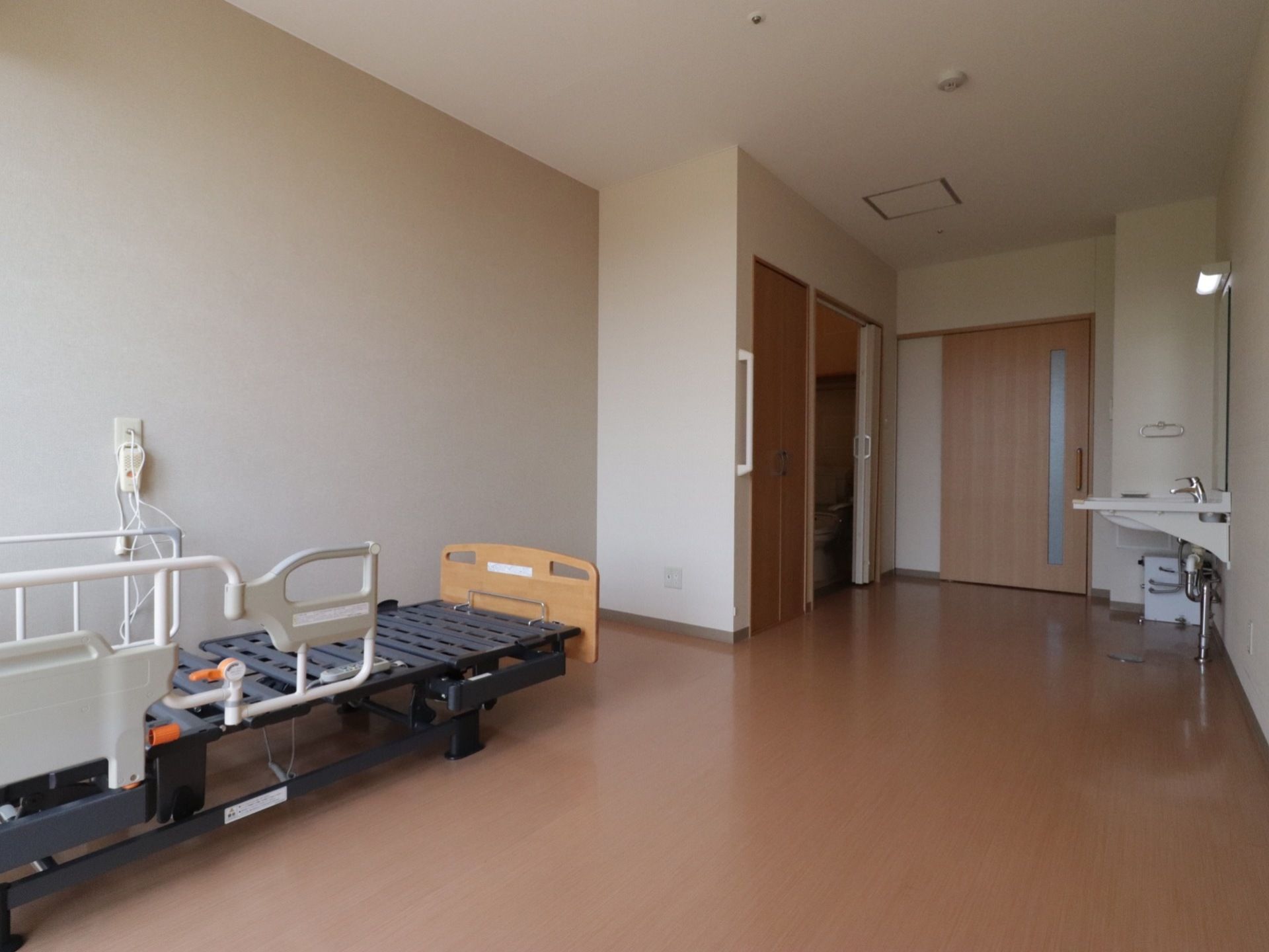 居室の出入り口やトイレスペースとの間には段差がなく、バリアフリー環境が整っている。天井には万一の時に備えて火災報知器が設置されている。
