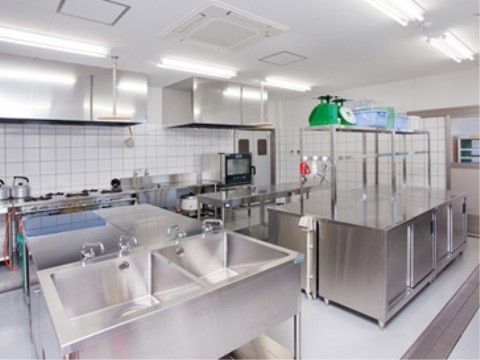 ステンレス製の大きな流し台や調理台が並んでいる業務用キッチン