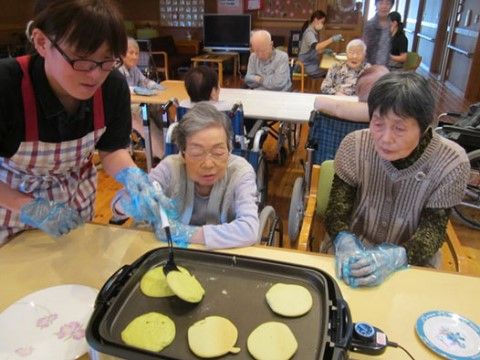 ホットプレートでホットケーキ造りをスタッフと一緒に楽しむ入居者様