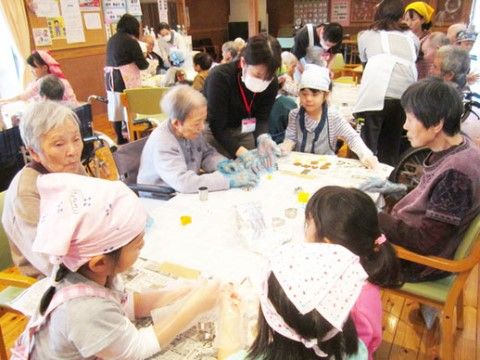 施設近隣の学校の児童と一緒にお菓子作りを楽しむ様子