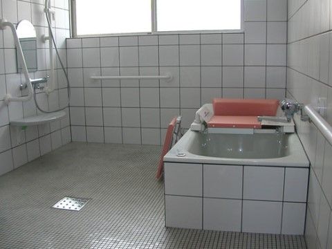 窓が設置され陽射しが入っている浴室である。白いタイルに黒い目地仕様で、浴槽も同仕様で統一されている。
