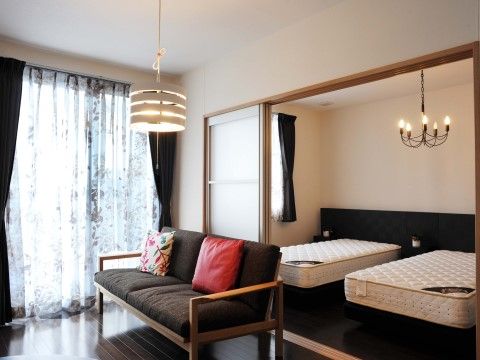 マットレスが置かれたベッドが２つ並べられた寝室と居住スペース