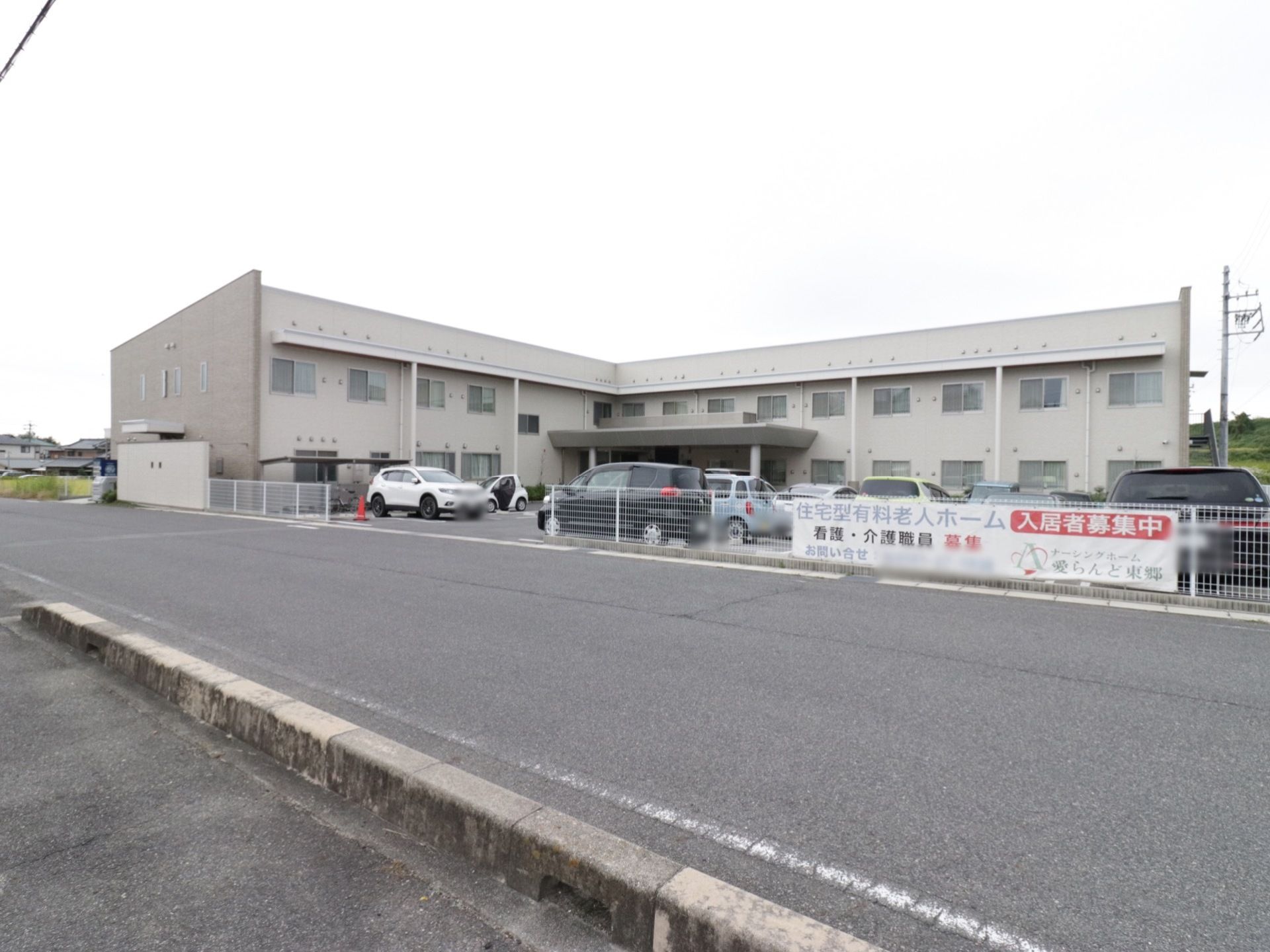 施設の周りには高い建物はなく、静かな雰囲気の場所となっている。また前には道路があり、反対側には歩道が設置されている。