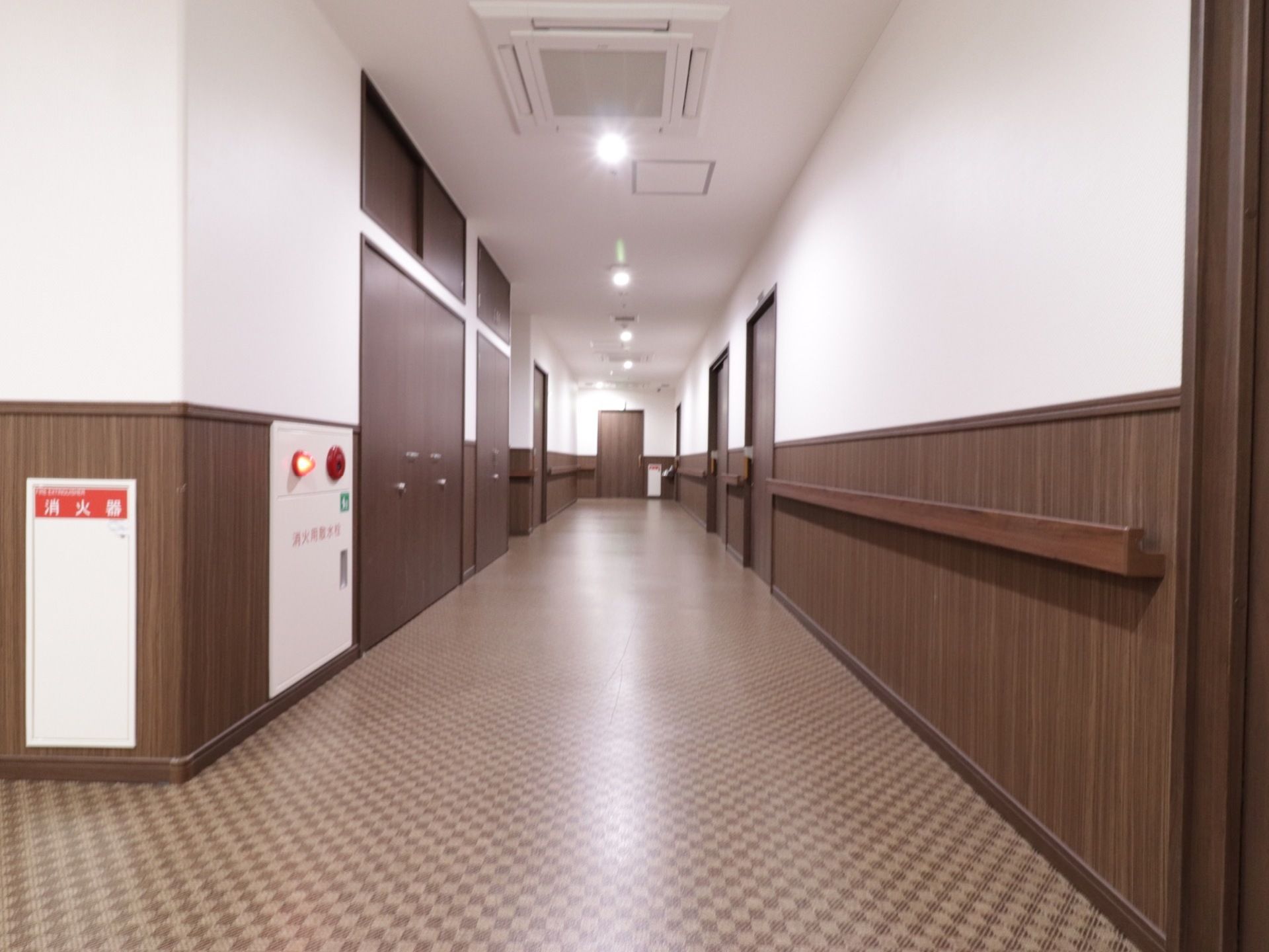 通路の天井には埋込み型の空調設備を備え付けている。またフロアには火災警報器があり、消火器を設置している。
