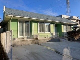 センターラインのある通りに面した、瓦の屋根に板張りの壁の建物