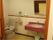 レッド系の手洗い場が印象的なトイレである。立ち座りを介助する手すりがつけられており、安全性を確保している。