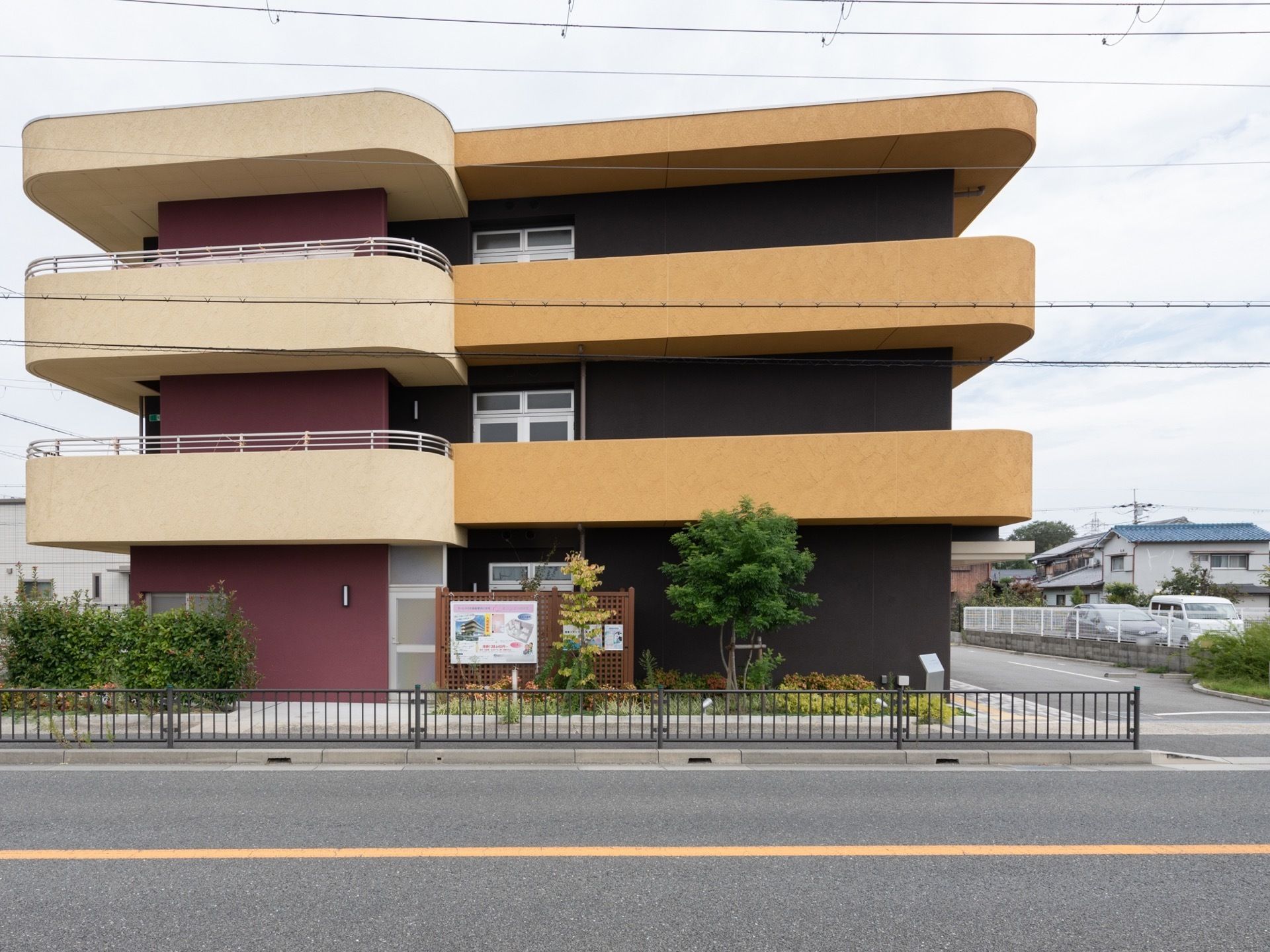 各階のベランダの屋根部分はオレンジとベージュに塗られ、縁にカーブを描いた形になっている。壁はダークブラウンである。