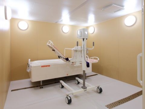 広いスペースに機械浴の設備が整えられている。壁に照明が取り付けられている。室内は清潔に保たれている。