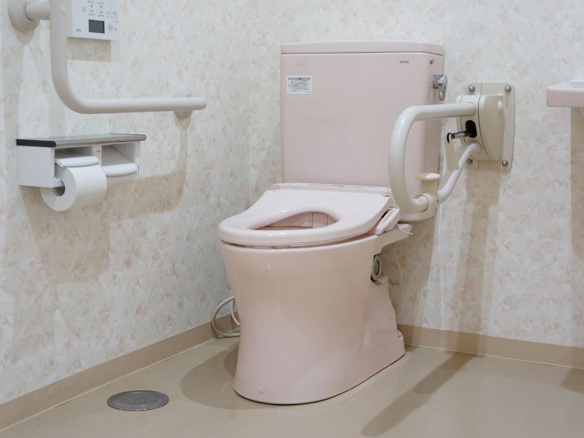 トイレは温水便座で、ウォッシュレットが完備されています。便座の左右に転倒防止の手すりが設置されている。