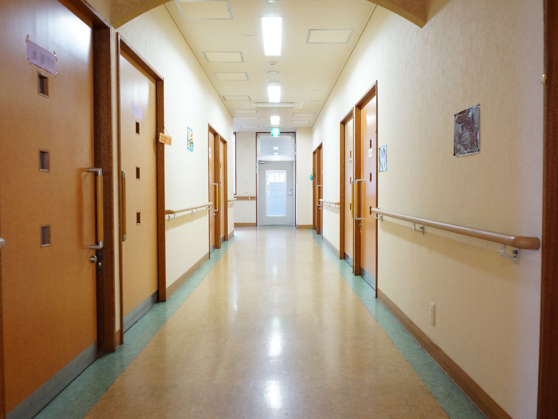 居室前の廊下は広々としていて、清潔が保たれている。各部屋のドアは同じく広めに作られ引き戸で、車いすの方にも利用しやすい。