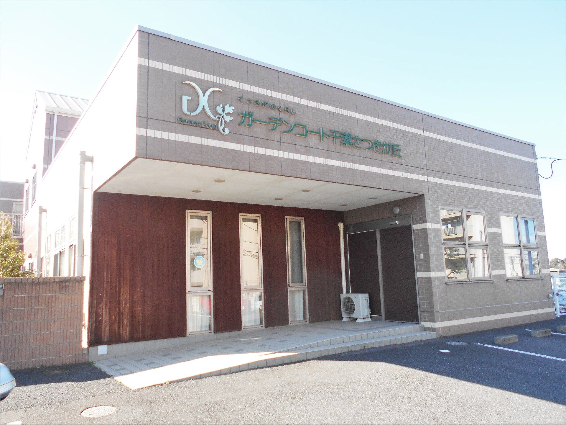 優しい薄ピンク色の建物で、駐車場も広い。奥には、緊急避難時用の階段もあり、もしもの場合に備えている。