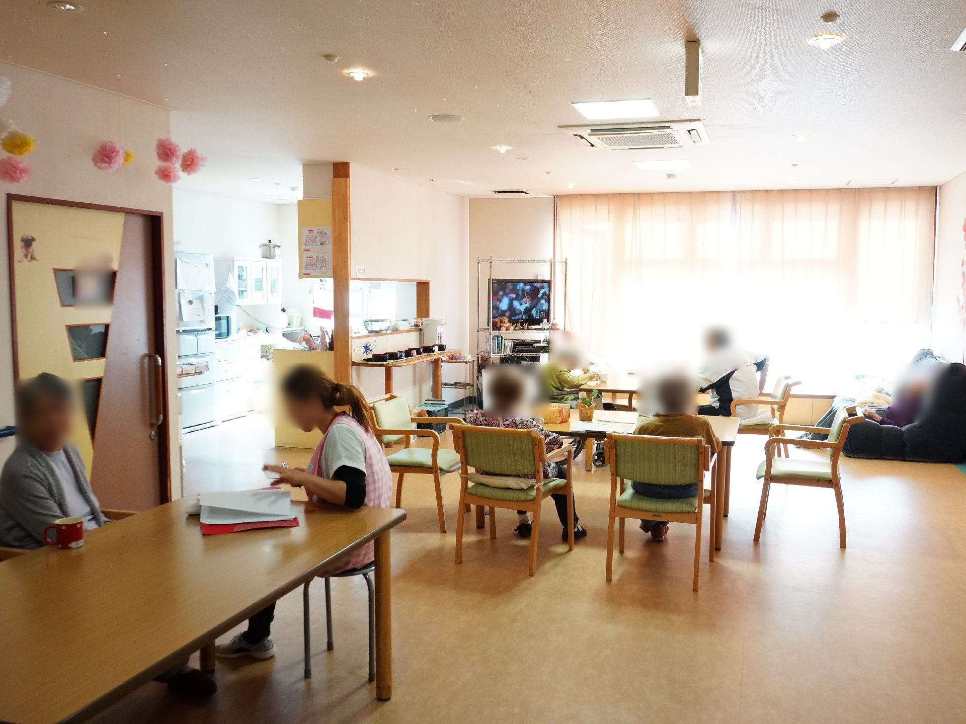食堂でくつろぐご入居者様と、サポートを行うスタッフ。