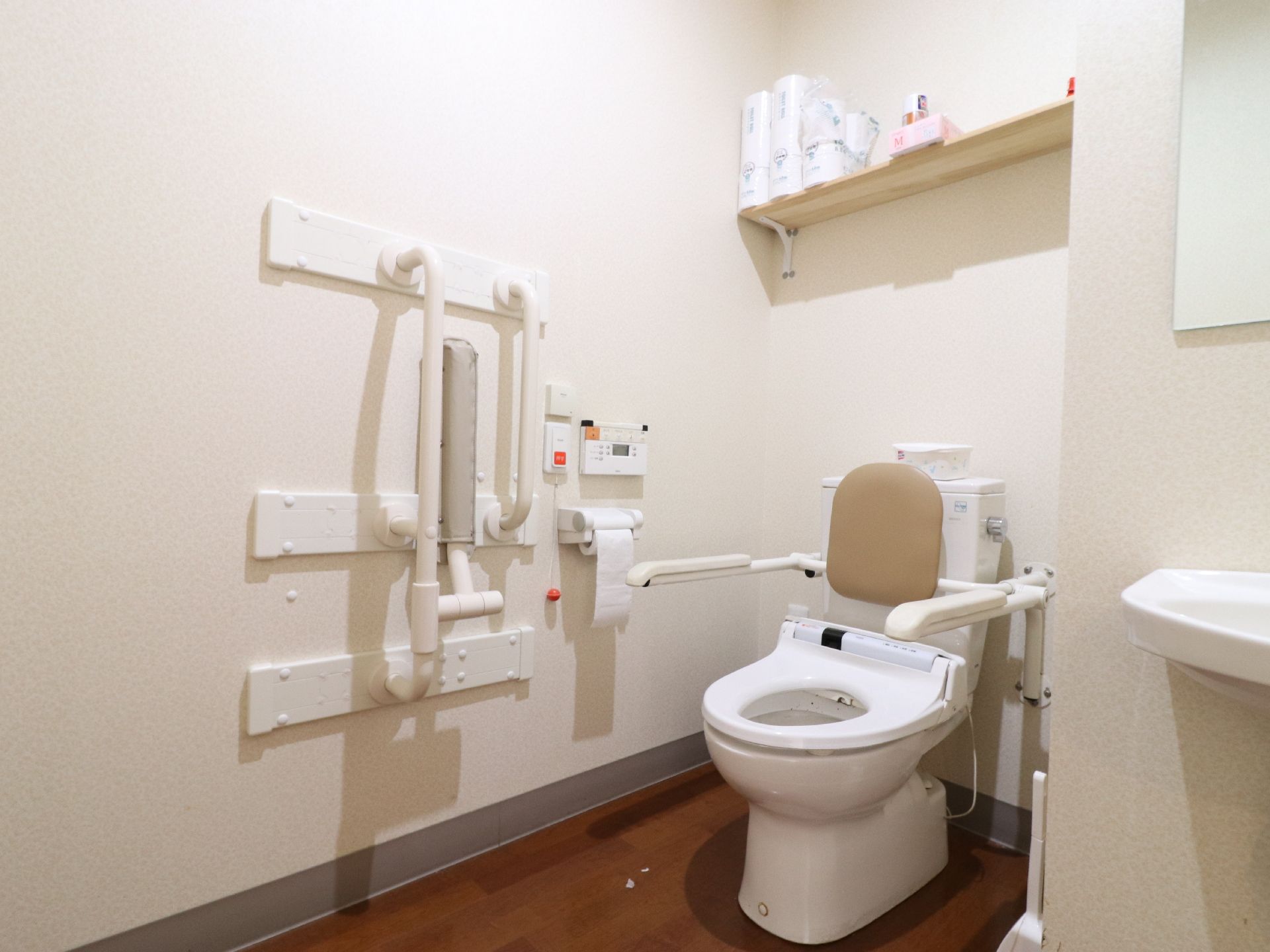 トイレには、手すりと背もたれが付いている。呼び出しブザーも付いていて、安心安全に用を足すことができる。