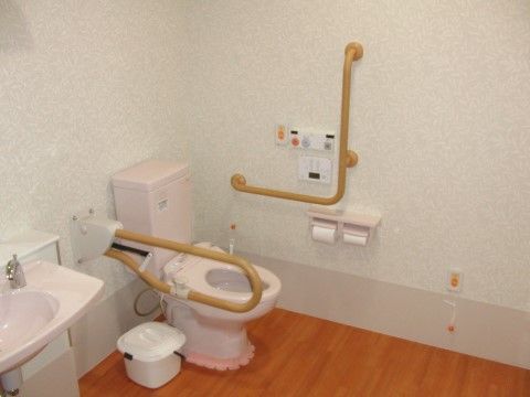 トイレの壁には呼び出しボタンが設置されている。便器の左側の壁にＬ字型、右側には、必要に応じて使えるように可動式の手すりが備え付けられている。