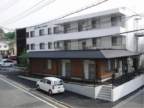 敷地内には数台の車を停められるスペースがある。スロープ、階段を上がると施設に入ることができるようになっている。