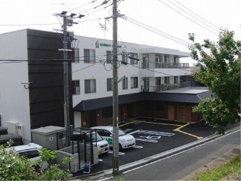 施設は白い外観の3階建てである。外壁には緑色で施設名が書かれており、敷地内には車椅子をご利用の方専用の駐車スペースが用意されている。